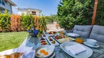 Enjoy a serene breakfast in our garden, surrounded by lush greenery and comfortable seating.