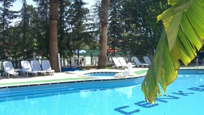 Una piscina al aire libre de temporada, sombrillas