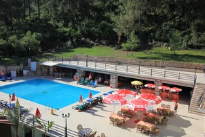 Una piscina al aire libre de temporada, sombrillas, tumbonas