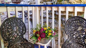 Un banc orné de motifs métalliques complexes et un jardinier avec des fleurs.