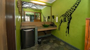 A kitchen with a green wall, a giraffe mural, a wooden countertop, and a built-in refrigerator. - Royala Inn (Montebello)