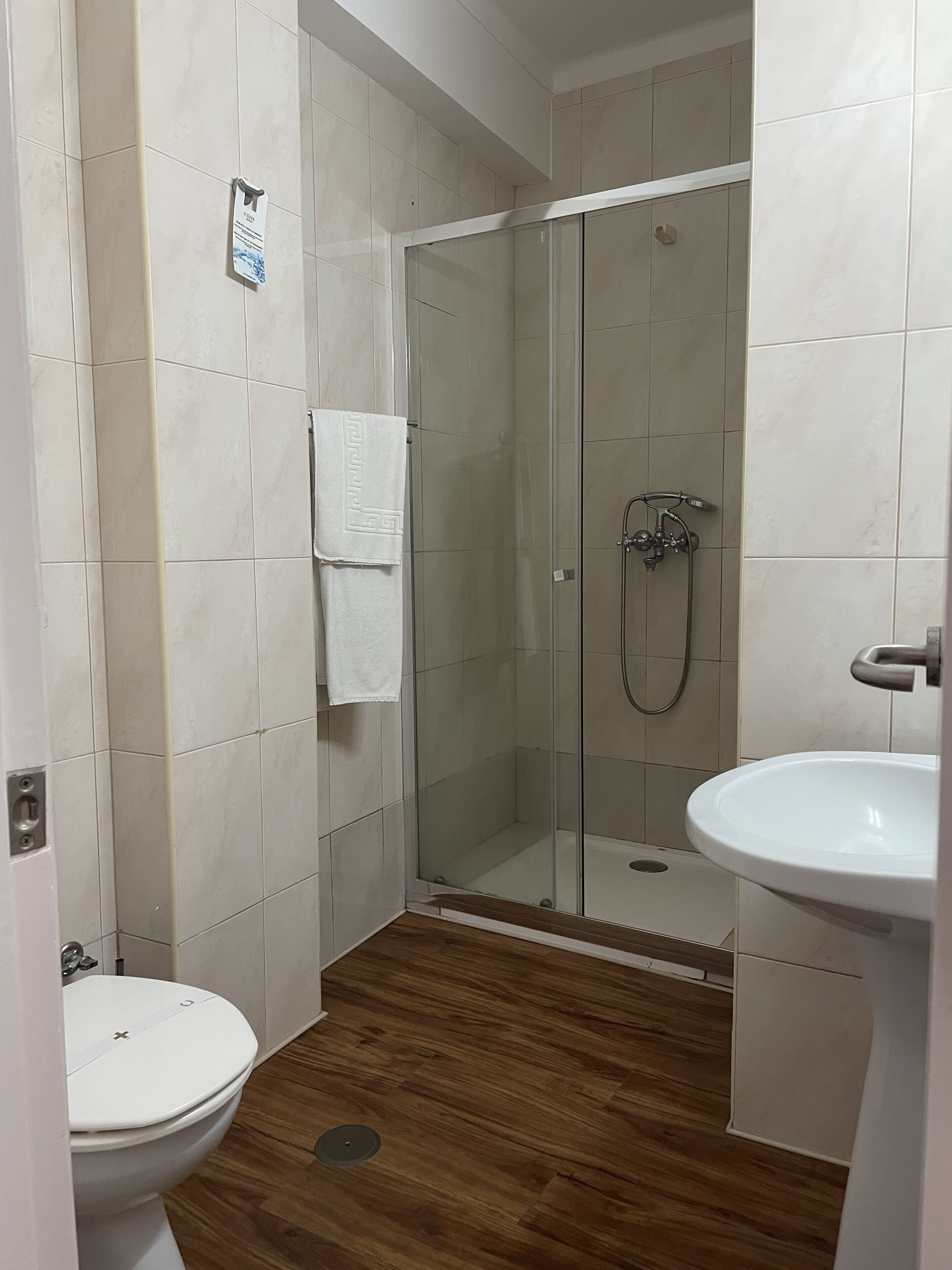 Ein Badezimmer mit Duschkabine, Toilette und Waschbecken.