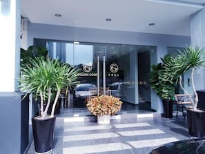A hotel entrance with a glass door, potted plants, and a sign reading 'GOLDEN COURT'. - Golden Court Hotel @ Taman Pelangi (Johor Bahru)