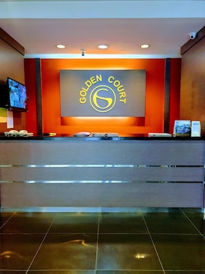 A reception desk with a 'Golden Court' sign, a flat-screen TV, and a digital display. - Golden Court Hotel @ Taman Pelangi (Johor Bahru)