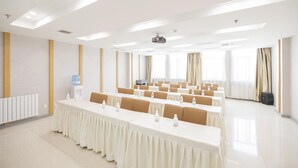 A conference room with long tables, chairs, a projector, and a water dispenser. - Ji Hotel (Xi'an)