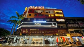 Un hôtel à plusieurs étages, avec des enseignes indiquant « Orange Hotels » et « SOMA Wellness ».
