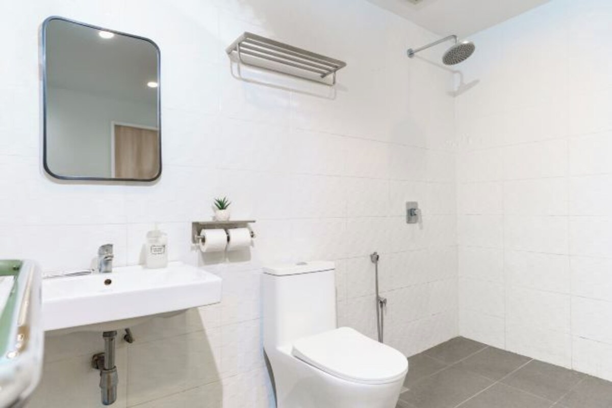 A bathroom with a white sink, toilet, and shower.