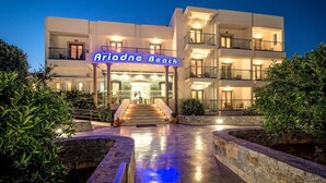Um hotel moderno com uma entrada imponente, várias varandas e fachada bem iluminada.