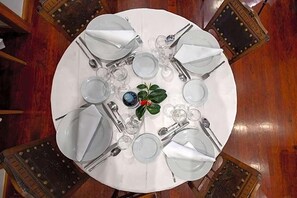 A round dining table set for six with white tablecloth, plates, cutlery, and glasses. - Universal (Terras de Bouro)