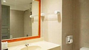 A bathroom with a sink, mirror, toilet, and towel rack.