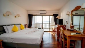A hotel room with a bed, a desk, a chair, a television, and a large window with a view.
