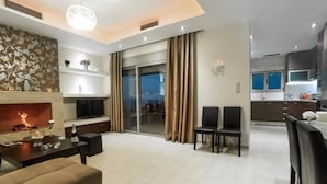 Una habitación de hotel moderna con chimenea, zona de comedor y cocina.