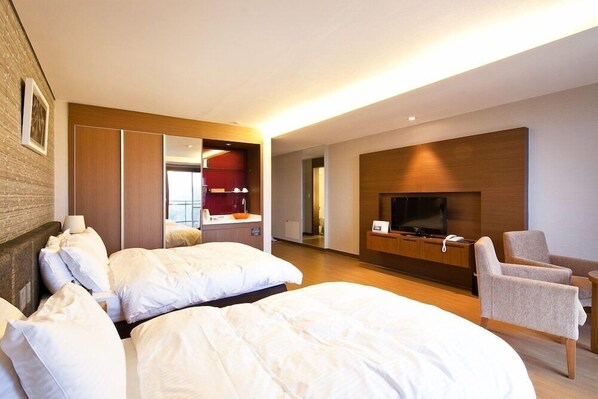 A hotel room with two beds, a TV, a desk, and a seating area. - Sono Belle Byeonsan (Buan)