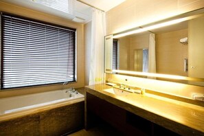 A modern bathroom with a bathtub, a sink, and a large mirror. - Sono Belle Byeonsan (Buan)