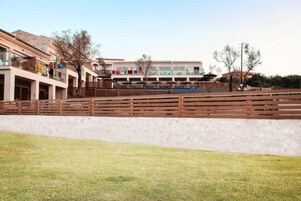 Un hotel con varios pisos, balcones y una piscina.