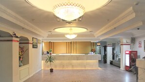 A hotel reception area with a chandelier, a reception desk, a Coca-Cola refrigerator, and a potted plant. - Miri Hotel (Miri)