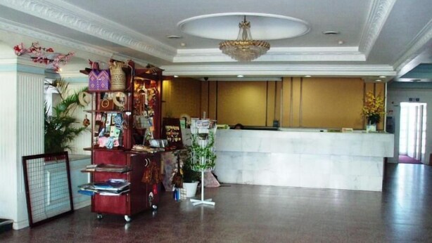 A lobby with a reception desk, a red vending machine, and a decorative plant. - Miri Hotel (Miri)