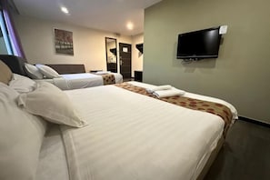 Quarto de hotel com duas camas, uma televisão de tela plana, um espelho e porta para o banheiro.