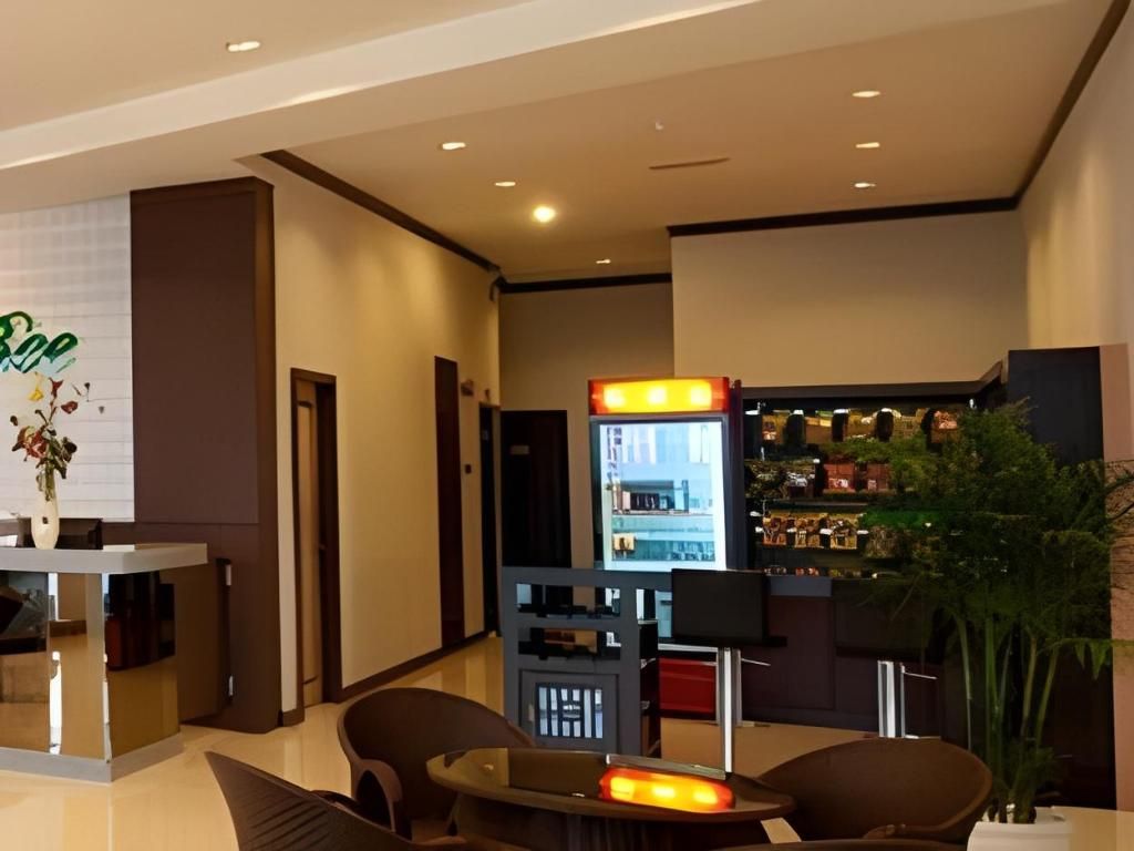 A hotel lobby with a reception desk, seating area, and a vending machine.