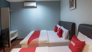 A hotel room with two beds, a desk, an air conditioner, and a framed picture on the wall. - OYO 89891 1st Inn Hotel Subang (Subang Jaya)