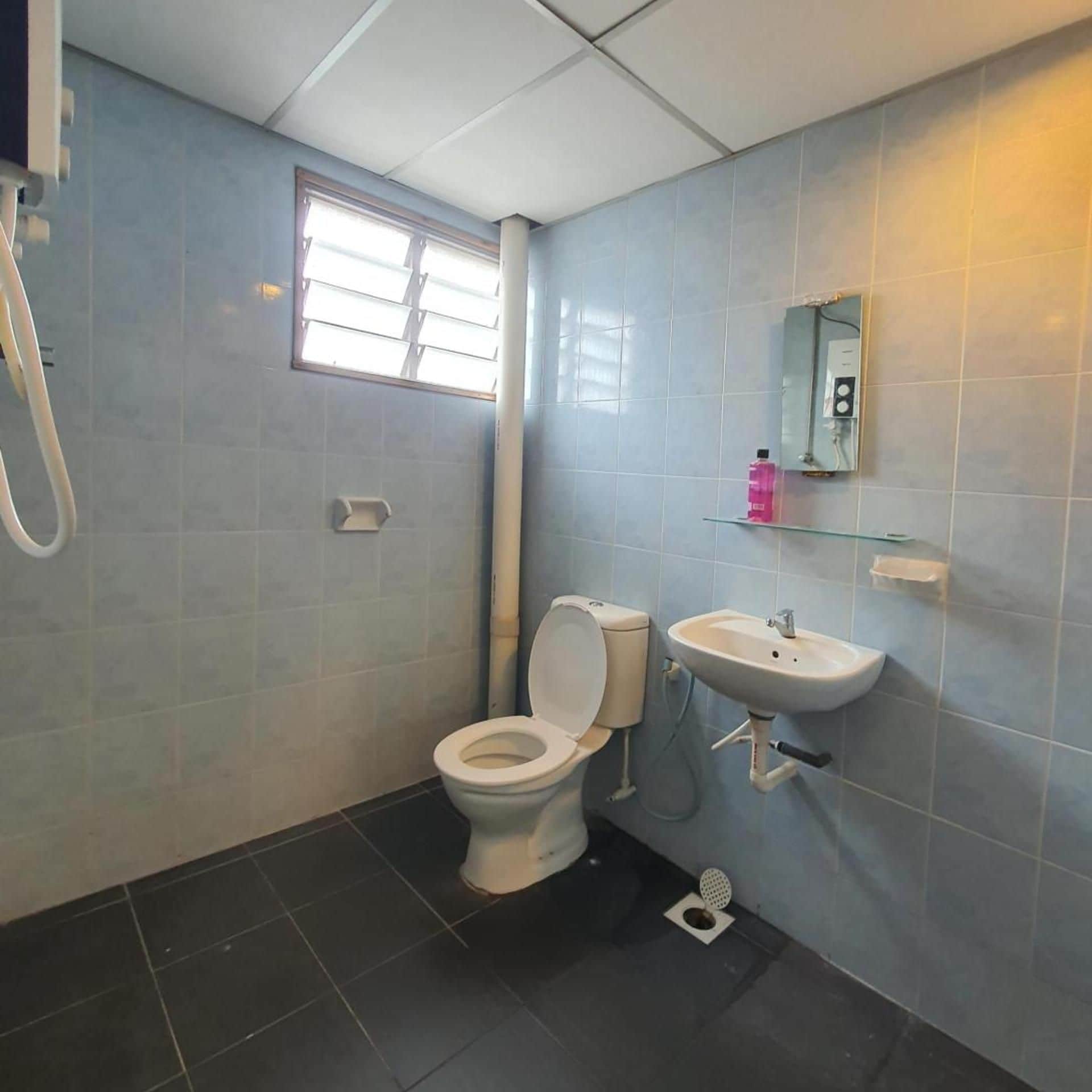 A bathroom with a toilet, sink, and shower.