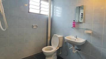 A bathroom with a toilet, sink, and shower.