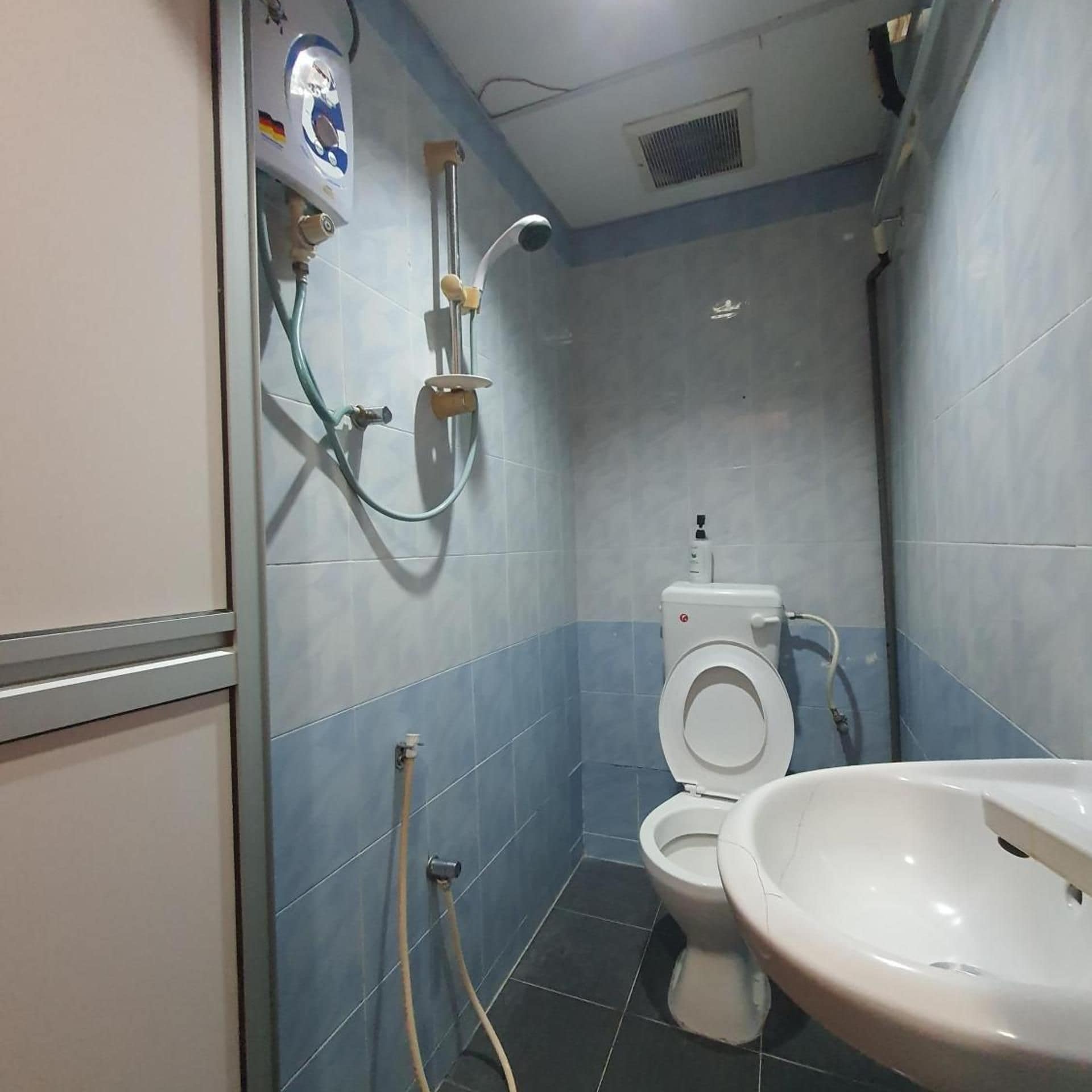 A small bathroom with a toilet, a sink, and a shower.
