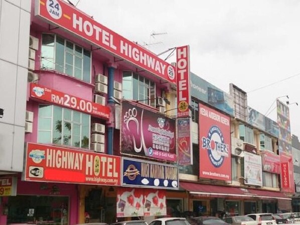 A hotel with a prominent red sign, multiple advertisements, and a visible price tag of RM29.00. - Highway Budget Hotel (Ipoh)
