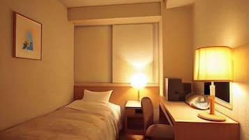A hotel room with a bed, desk, chair, lamp, and a framed picture on the wall.