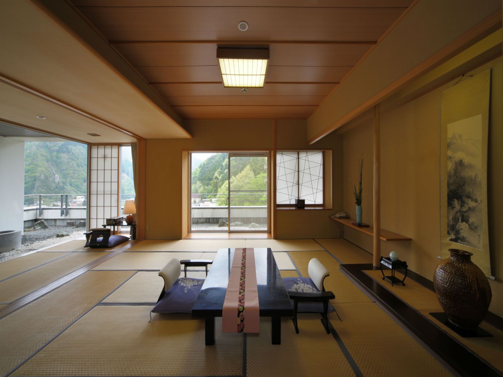 Una habitación japonesa tradicional con suelo de tatami, una mesa baja y puertas correderas.