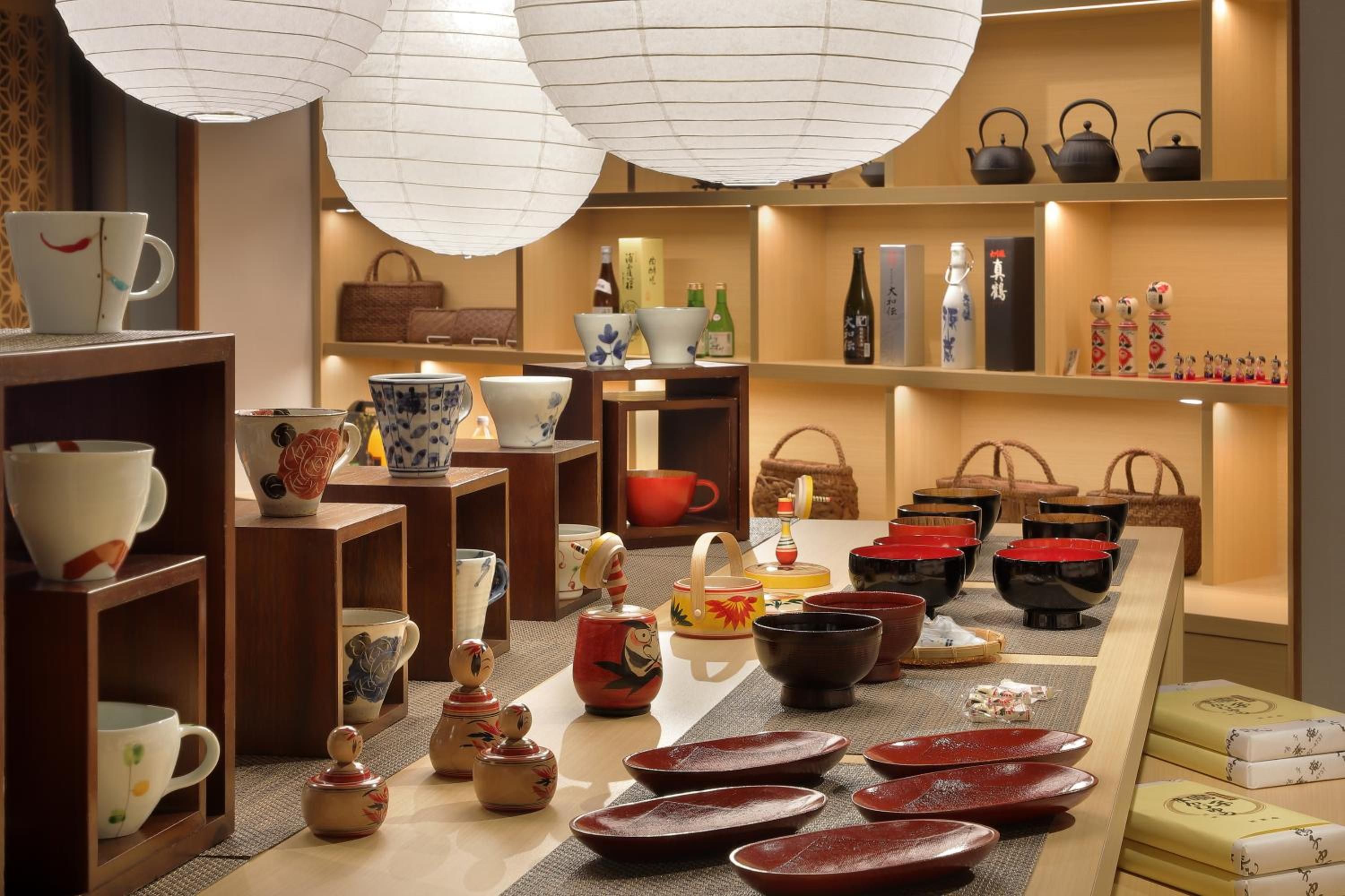 A variety of ceramic items displayed on shelves and tables, including cups, bowls, and teapots.