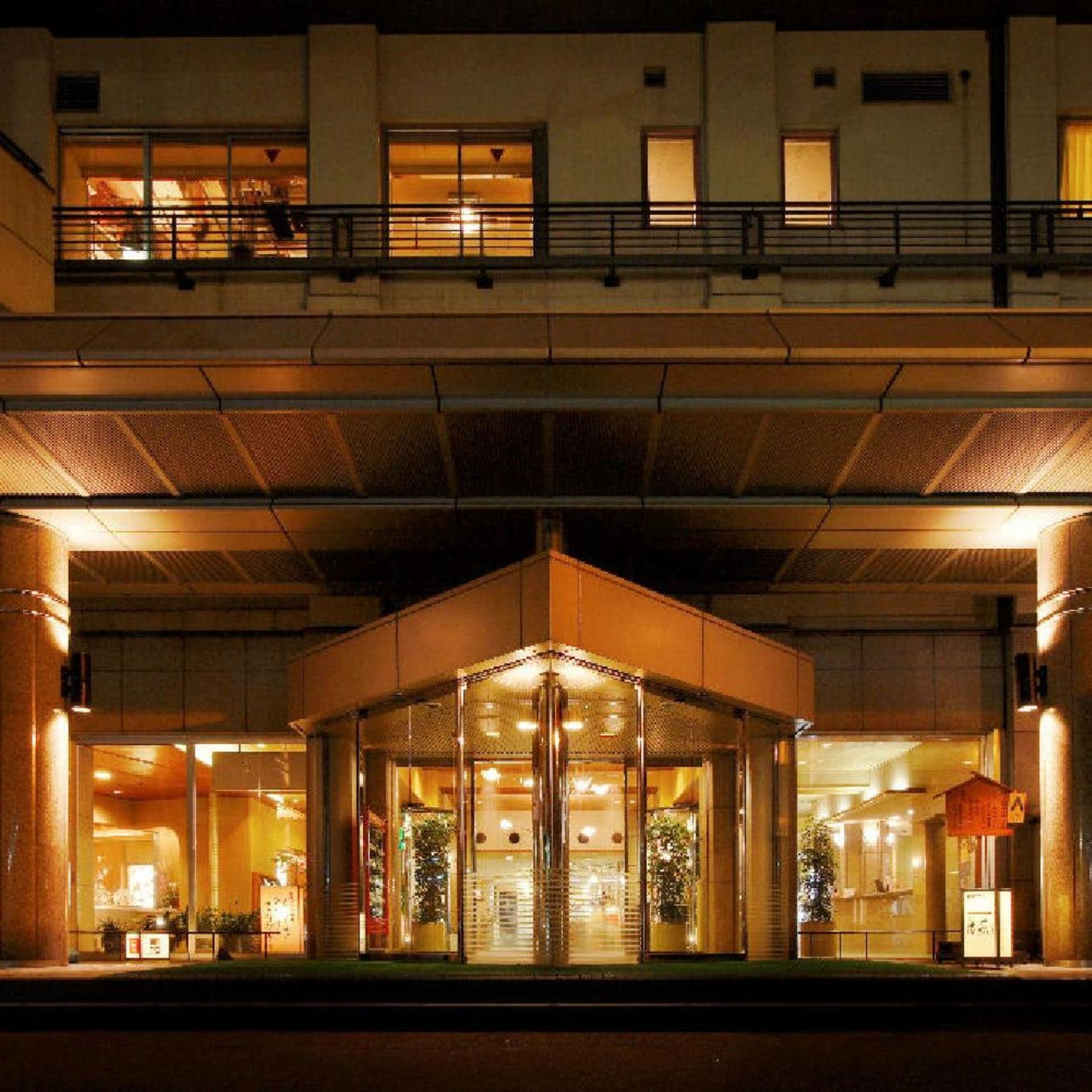 A hotel entrance with a covered lobby area, glass doors, and a visible reception desk.