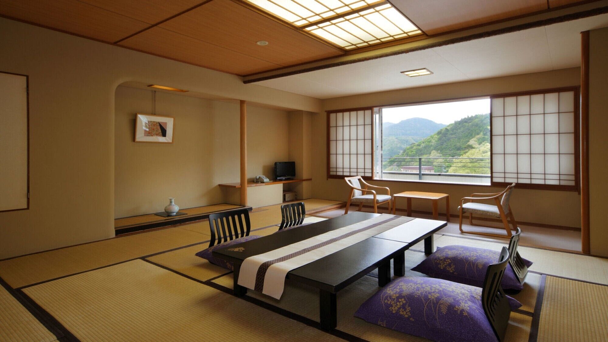 Una habitación japonesa tradicional con suelo de tatami, una mesa baja y sillas.