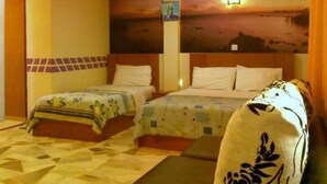 Een hotelkamer met twee bedden, een kamerkleed met dessin, een schilderij aan de muur en een houten hoofdbord.