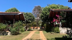 A pathway leading to a building with a covered porch area, surrounded by greenery and trees. - Pousada Jardim da Chapada (Chapada dos Guimarães)