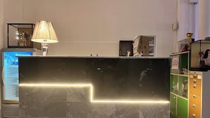 A reception desk with a marble finish and a neon light strip. - 99 Inn Hotel (Pak Chong)