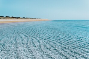 Plage privée, sable blanc, parasols, serviettes de plage