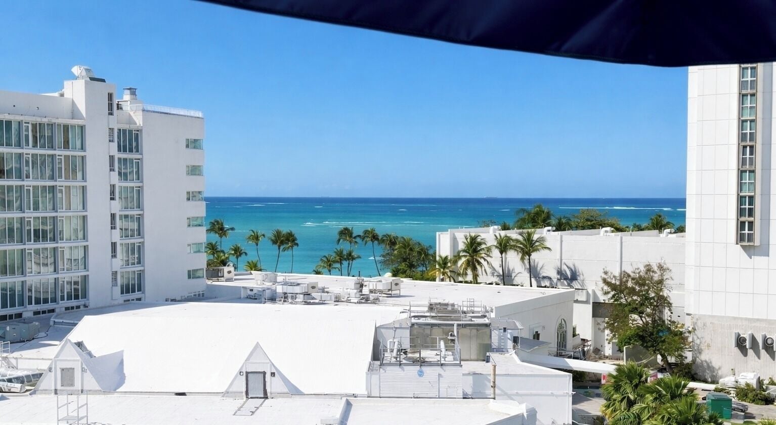 Una terraza con vistas al océano y palmeras.