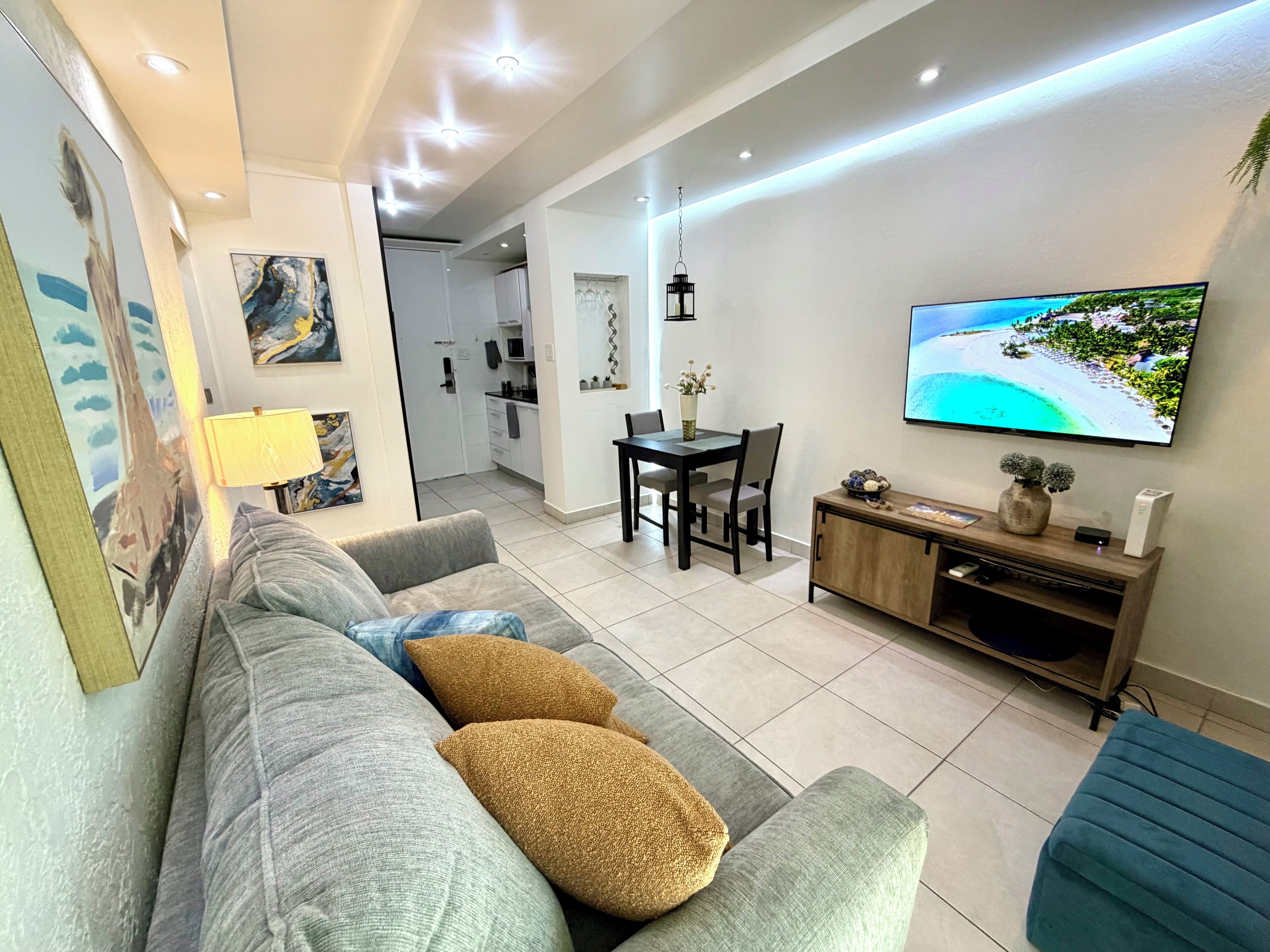 Ein modernes Wohnzimmer mit einer Couch, einem Fernseher und einem Essbereich.