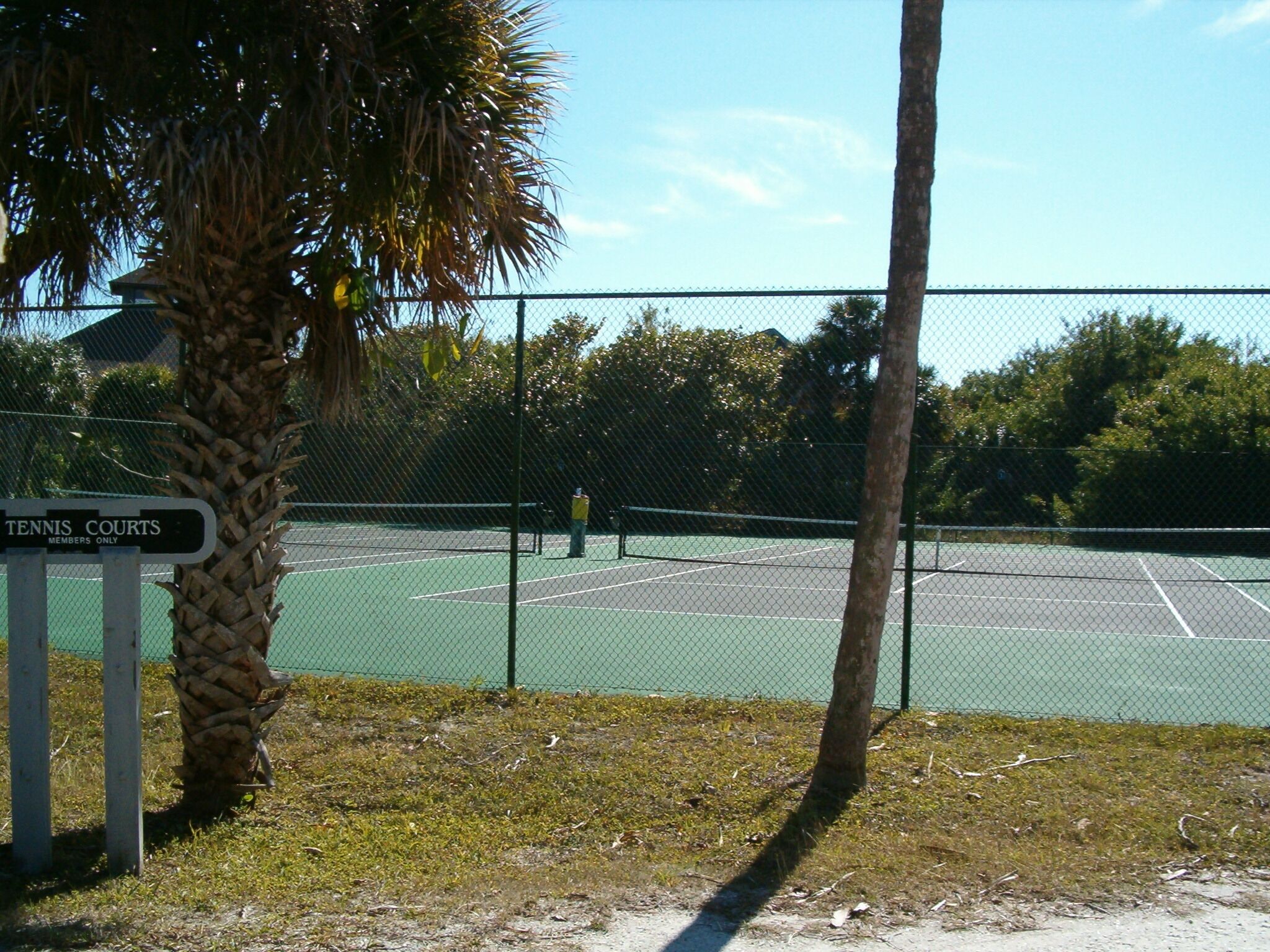 A tennis court with a sign indicating it is a members-only area.