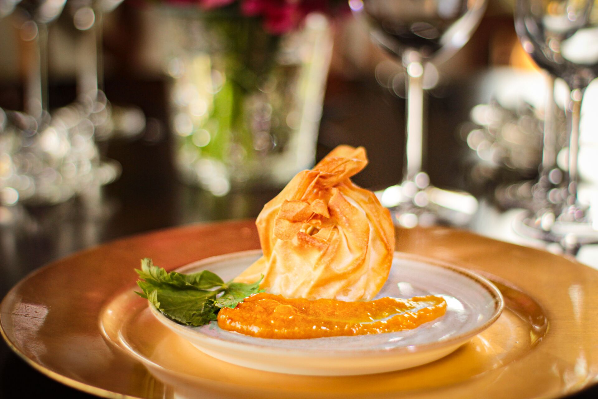 A dessert on a plate with a garnish, set on a table with a blurred background.