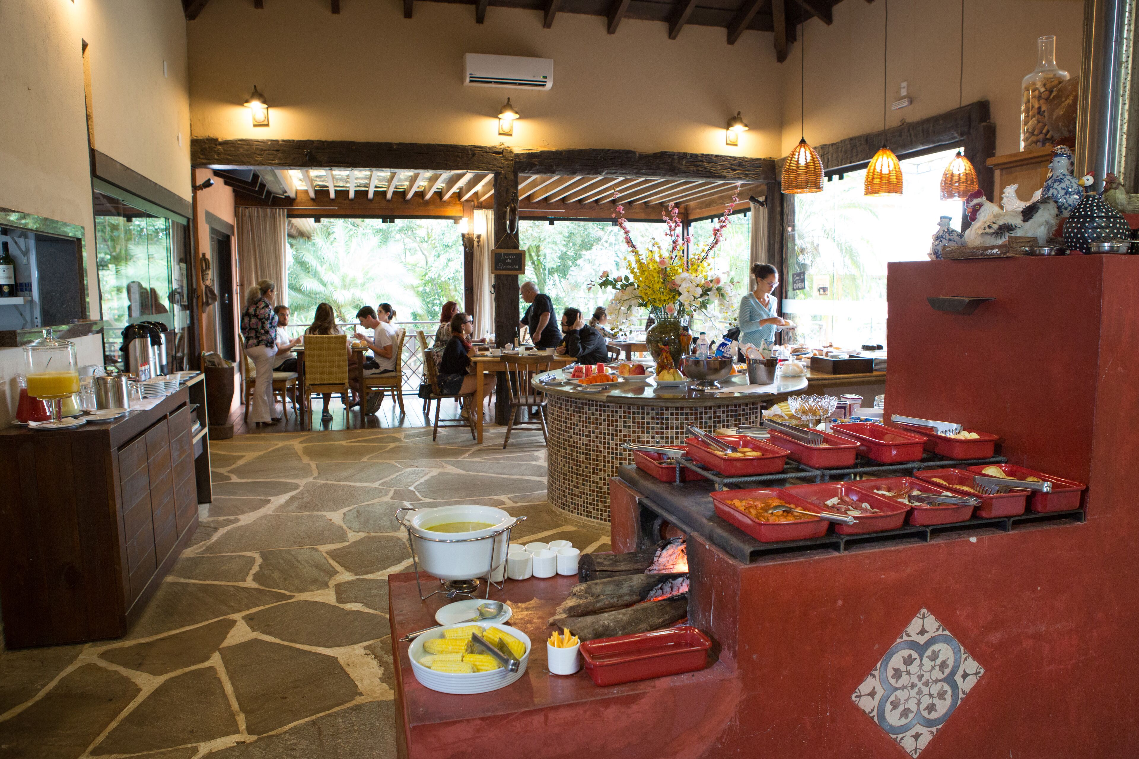 Un comedor con un sistema de bufé, suelo de piedra y vistas al exterior.