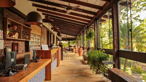 Un grand espace d’accueil avec un comptoir en bois, des ordinateurs et un mur en briques doté d’étagères.