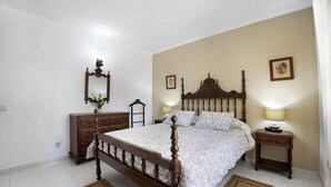 A bedroom with a wooden four-poster bed, a dresser, a nightstand, and a mirror. - Large private villa, saltwater pool, great holiday in the Algarve (Carvoeiro)