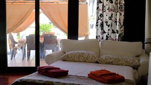 Habitació d'hotel amb un llit, dos almoinos i una finestra amb cortines.