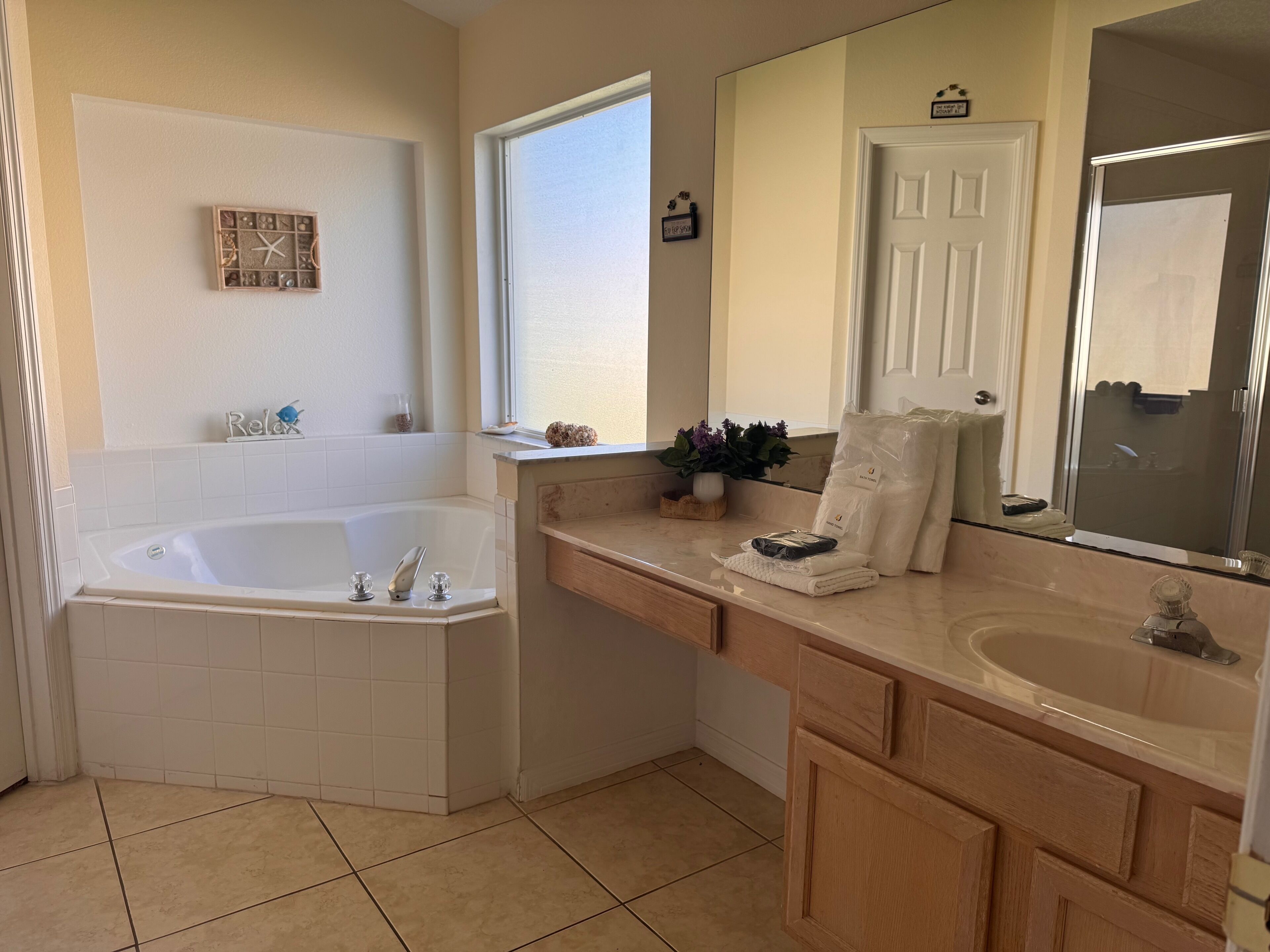 A modern bathroom with a freestanding bathtub, a large mirror, and a vanity with a sink.
