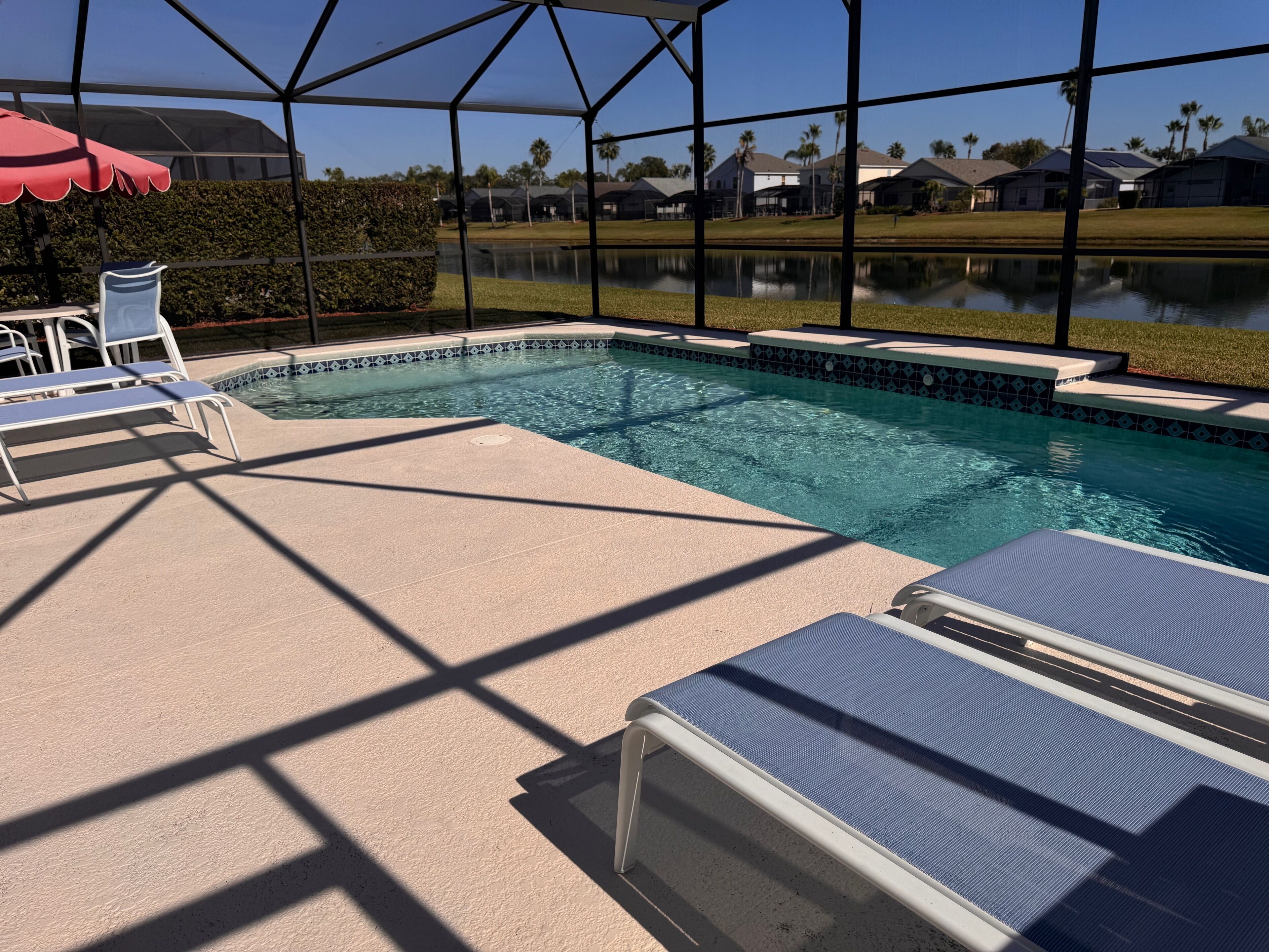 A pool area with lounge chairs and a covered section.