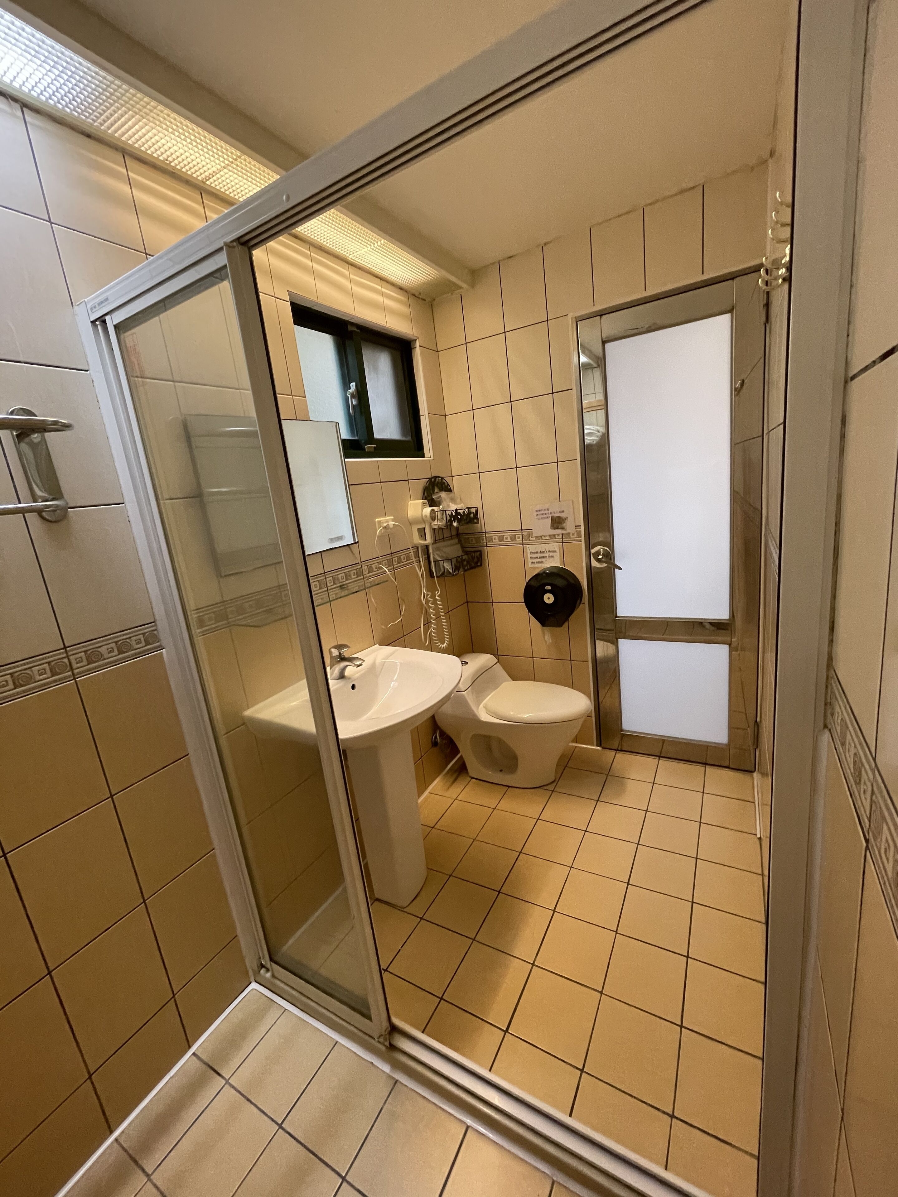 A modern bathroom with a glass shower enclosure, a sink, and a toilet.