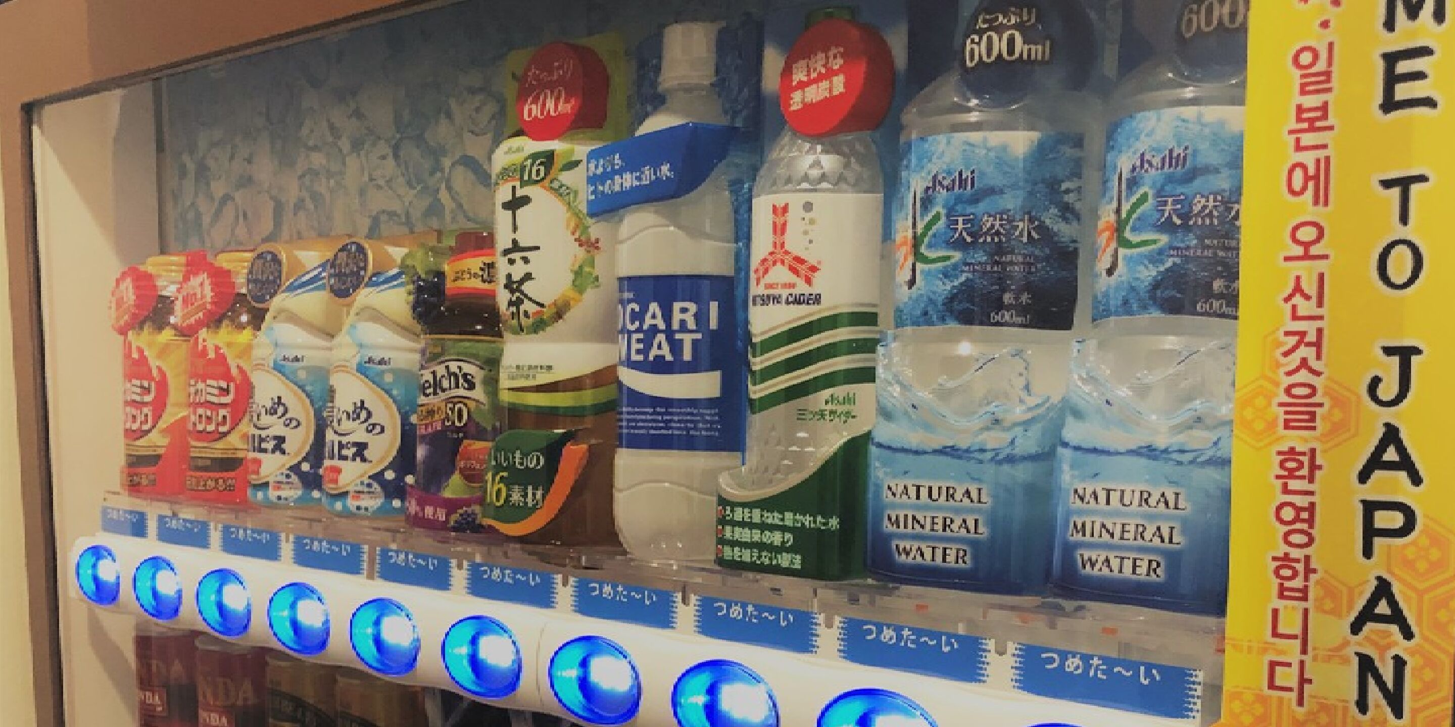 A vending machine with various beverages including natural mineral water and other drinks.