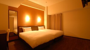 Una habitación de hotel con una cama grande, una silla, un espejo y un ventanal con cortinas.